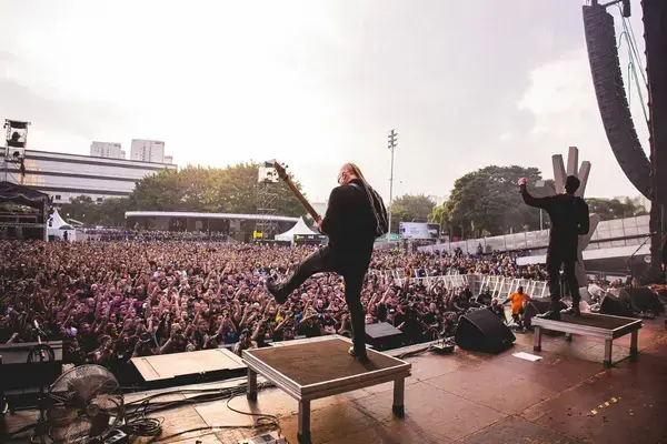Guitarrista no palco do Bangers Open Air com público lotado ao fundo