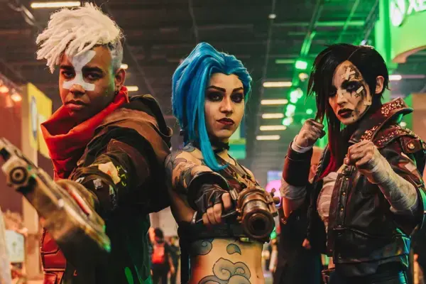 Cosplayers fantasiados posando em frente a um stand de games na CCXP