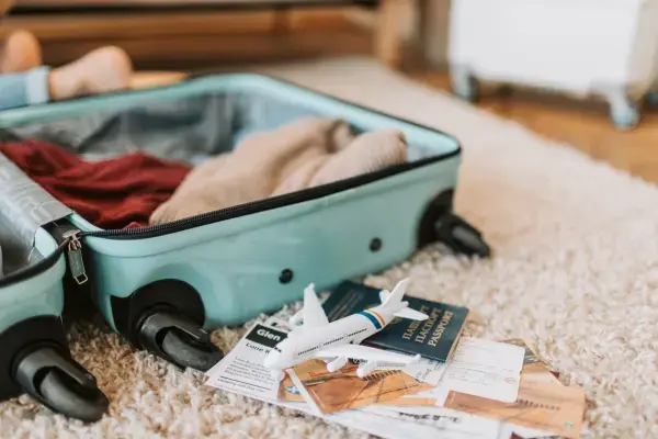 Mala aberta com passaporte e passagem prontos para viagem internacional em família