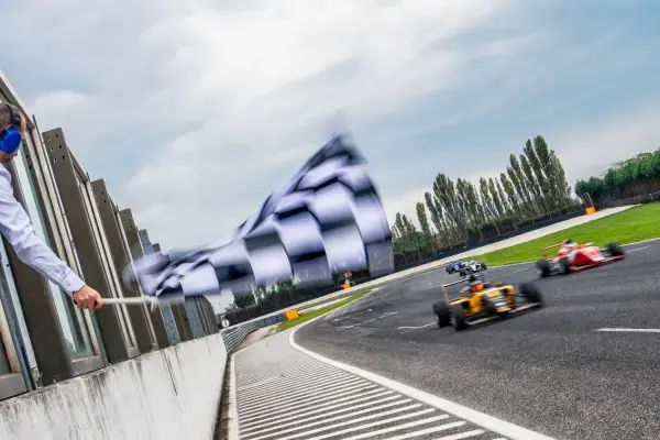 carros de formula 1 passando por bandeira de chegada (Fonte: Canva)