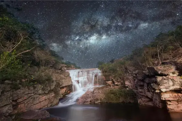 Cachoeira na Chapada Diamantina sob céu estrelado com Via Láctea visível