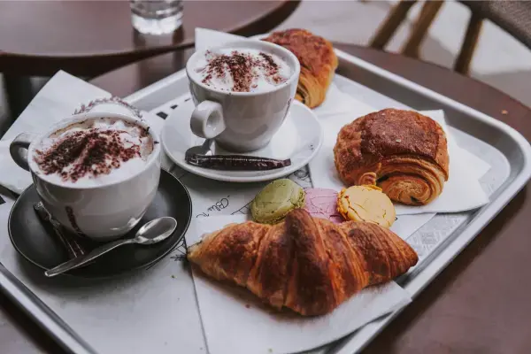 Croissants, macarons e cappuccinos em café parisiense
