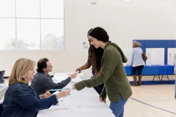 Mulher entregando documento para votar nas eleições