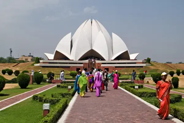 Templo de Lótus com arquitetura branca em formato de flor e visitantes no jardim.