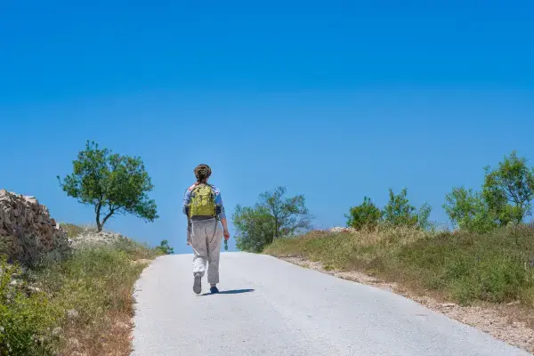 Peregrina andando em estrada a caminho de Santiago de Compostela