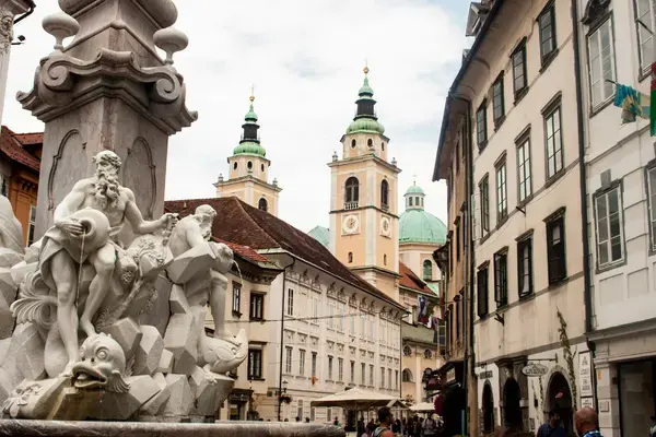 Escultura da Fonte Robba e torres da Catedral de São Nicolau em Ljubljana