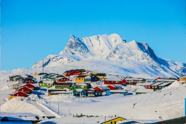 casas em primeiro plano cobertos de neve. ao fundo, montanha nevada. Groenlândia