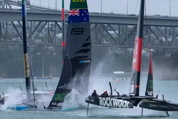 Catamarãs F50 do SailGP em alta velocidade durante regata, com barcos voando sobre a água.