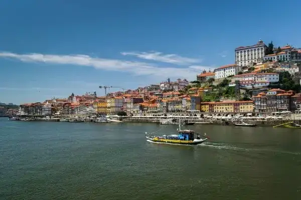 Cidade de Porto, em Portugal: barcos no rio e casas