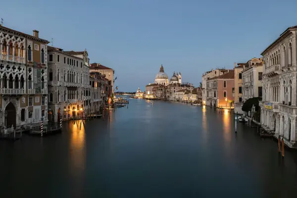 Grande Canal de Veneza ao entardecer com palácios históricos iluminados