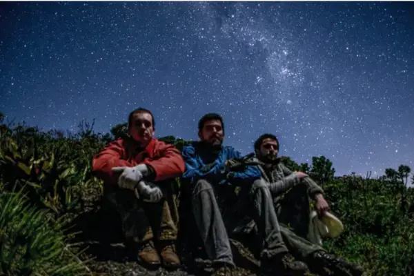 Três visitantes observam o céu estrelado no Parque Estadual do Desengano