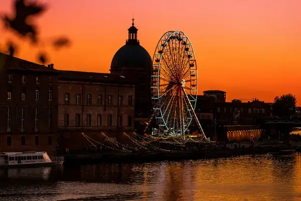 Rio Garonne ao pôr do sol com cúpula de La Grave em Toulouse