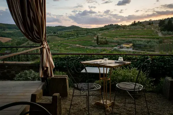 Terraço com vista para colinas e vinhedos da Toscana ao entardecer — viagem pela Itália