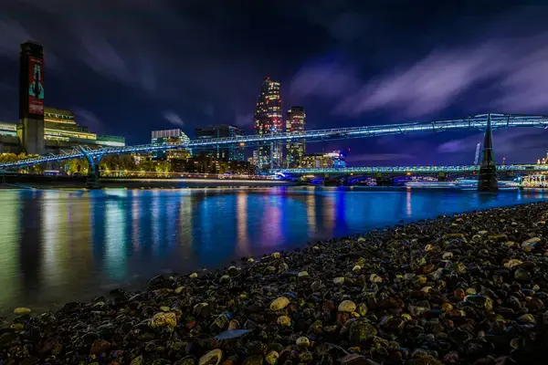Tate Modern e Millennium Bridge iluminados à noite às margens do Tâmisa