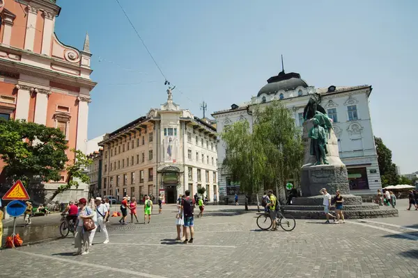 Praça Prešeren em Ljubljana com Igreja Franciscana e turistas caminhando