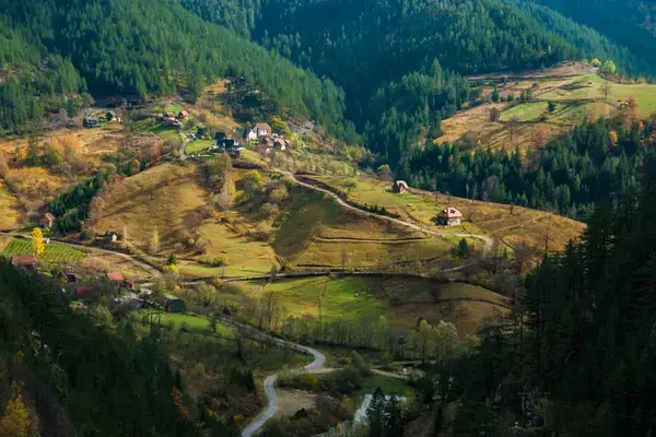 Casas espalhadas entre colinas e florestas nas montanhas da Sérvia.