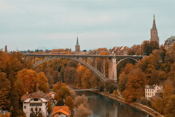Ponte cercada por árvores em tons de outono na Europa.