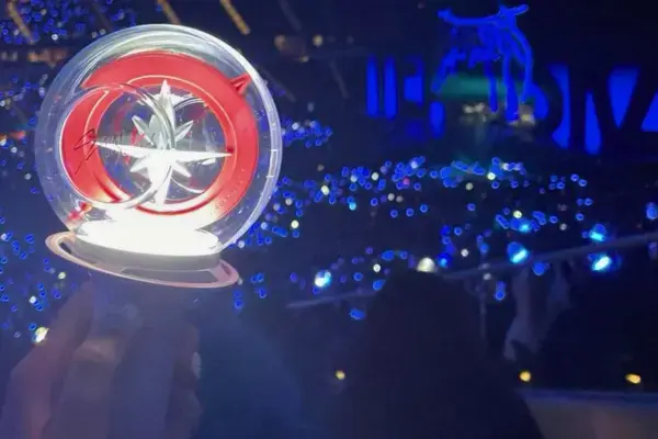Lightstick do Stray Kids aceso durante show em estádio lotado, com fãs STAY reunidos para apresentação da banda em grande festival.