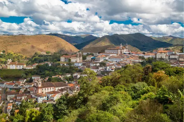 Hotel em estilo alpino em Monte Verde rodeado por áreas verdes e montanhas.
