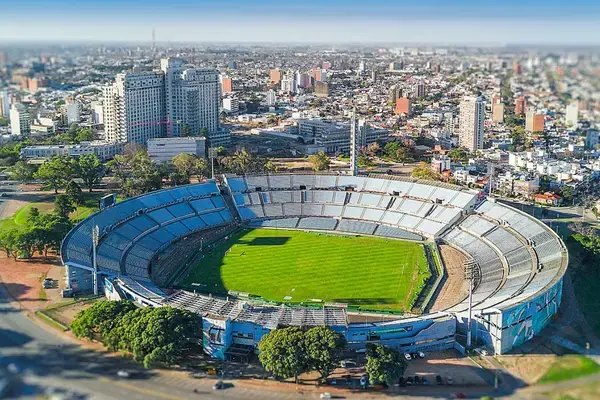 Vista aérea do Estádio Centenário em Montevidéu, com a cidade ao fundo.