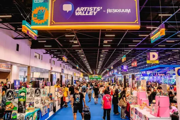 Corredor da Artists' Valley na CCXP, com estandes de arte e público fazendo compras