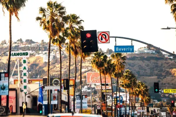 Rua com palmeiras e placas de Beverly Hills em Los Angeles.