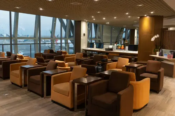 Sala VIP de aeroporto com poltronas e vista para a pista de embarque
