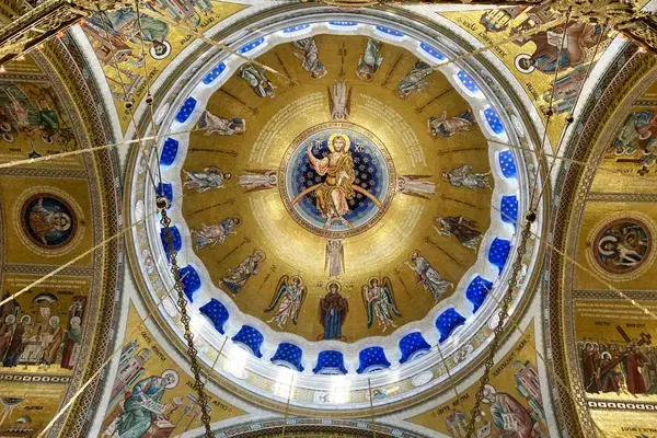 Cúpula do Templo de São Sava em Belgrado com mosaicos dourados e figuras religiosas.