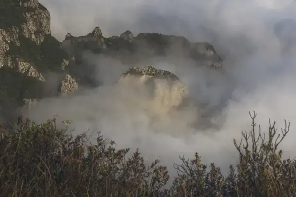 Pedra Furada parcialmente encoberta pela névoa. O arco rochoso formado naturalmente está localizado no Parque Nacional de São Joaquim, Urubici, Santa Catarina, Brasil.