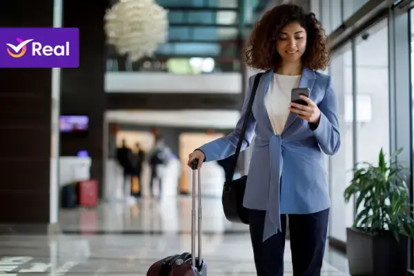 mulher jovem negra segurando mala e celular prestes a viajar