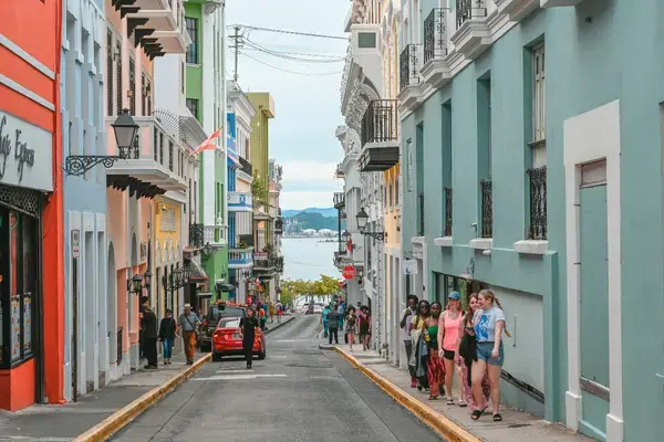 Rua colorida do Old San Juan em declive com vista para a baía