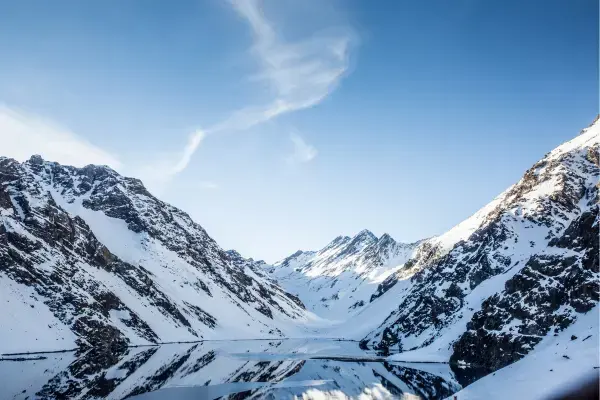Lagoa entre montanhas nevadas da Cordilheira dos Andes no inverno do Chile