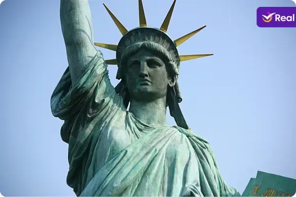 Estátua da Liberdade, focada nos detalhes de seu rosto e mãos