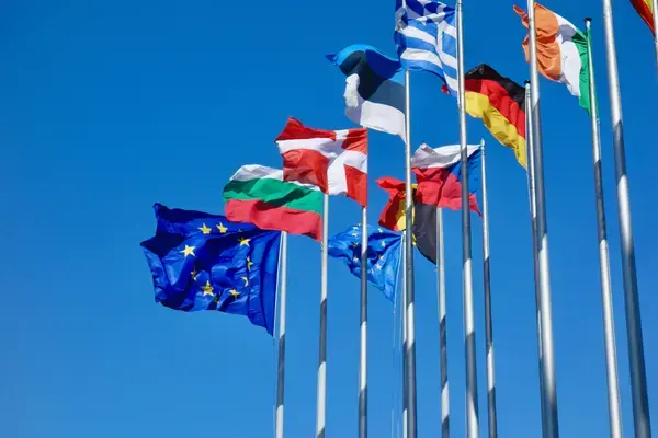 Bandeiras da União Europeia e de países europeus sob céu azul