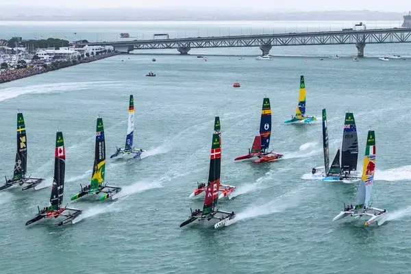 Vista aérea de etapa internacional do SailGP com catamarãs F50 competindo em circuito urbano à beira-mar.