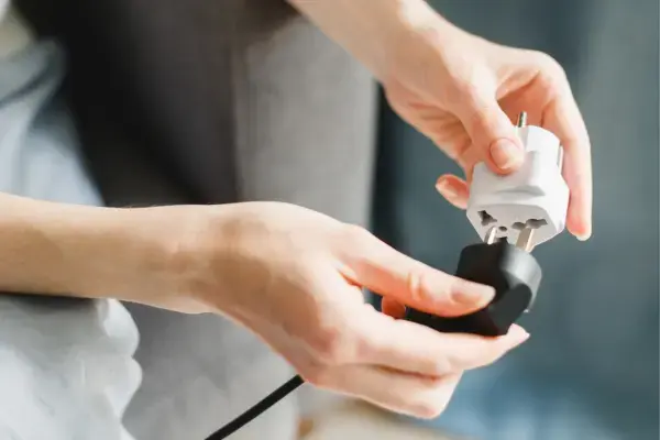 Mulher conectando um adaptador universal de tomadas