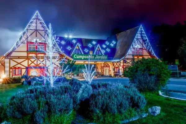 Entrada iluminada de Campos do Jordão decorada para o Natal durante a noite.