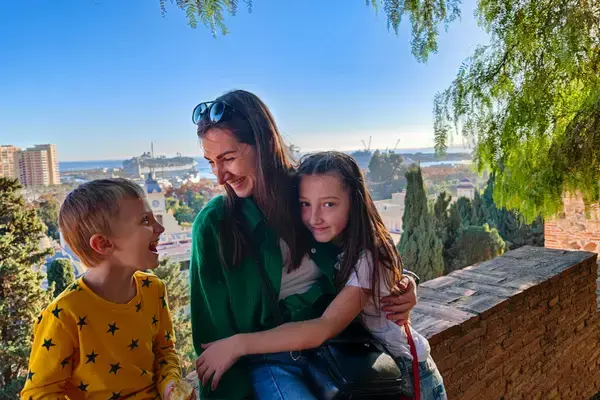 Mãe e duas crianças em mirante durante viagem pela Espanha