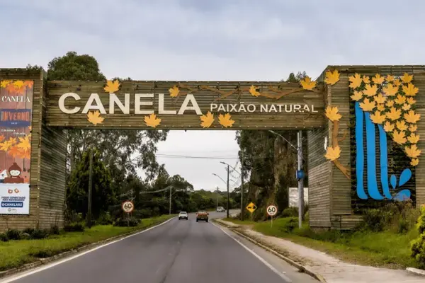 Pórtico de entrada de Canela/RS, decorado com folhas de outono e a rodovia ao fundo