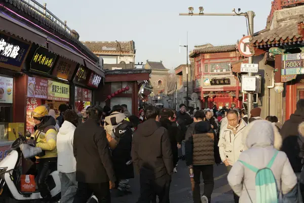 Multidão circulando por rua comercial na China, exemplo de grande concentração de pessoas
