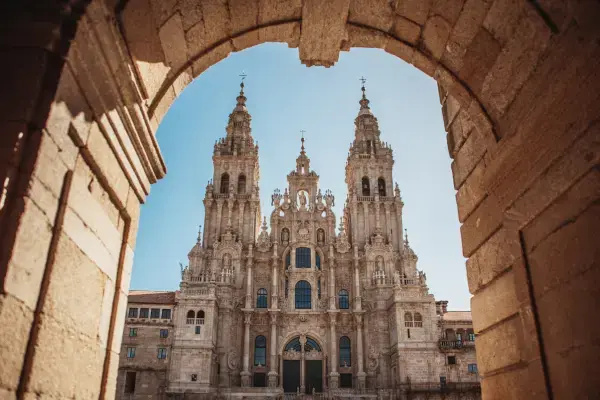 Fachada barroca da Catedral de Santiago de Compostela vista através de arco de pedra