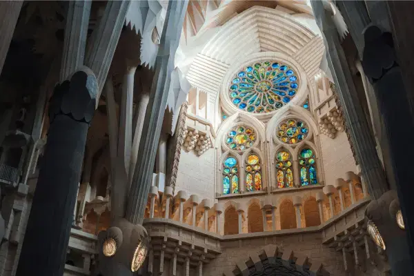 Vitrais da Sagrada Família projetando luz colorida dentro da basílica em Barcelona.