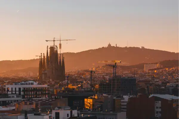 Sagrada Família ao pôr do sol vista de longe com a cidade de Barcelona.