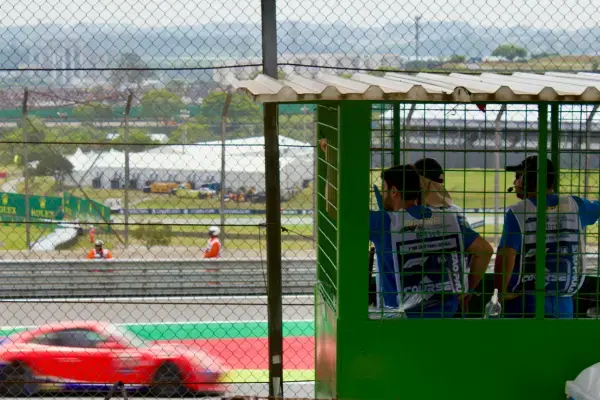 Público e fiscais acompanham carro passando na pista de Interlagos