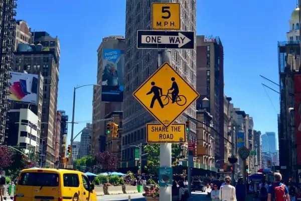 Placas de trânsito em Nova York indicando limite de velocidade e via compartilhada