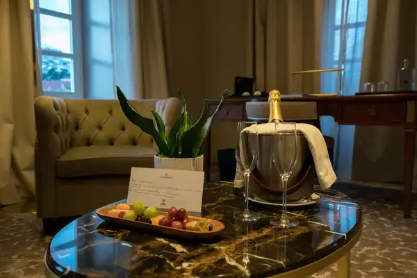 Espumante, taças e frutas preparados em uma suíte de hotel para lua de mel.